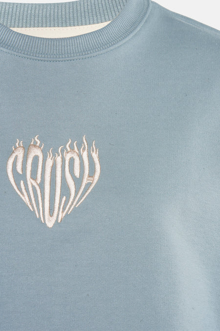 Gilet turquoise de KAOTIKO avec un design 'CRUSH' en forme de cœur.