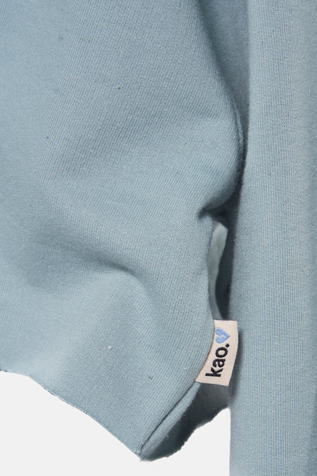 Gilet Turkooizen de KAOTIKO, avec étiquette de marque et texture douce.