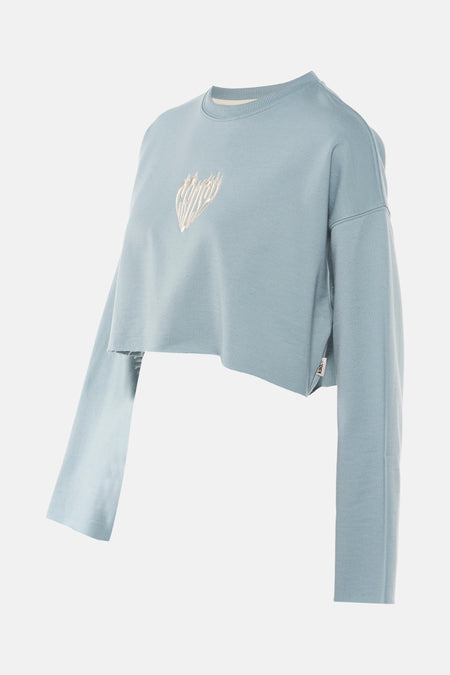 Gilet turquoise de KAOTIKO, avec des manches longues, modèle crop top et un détail brodé.