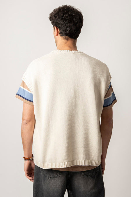 T-shirt écru de KAOTIKO, avec des manches rayées en brun et en bleu, vu d'arrière sur un homme.
