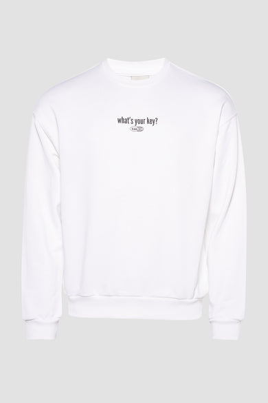 Pull-over blanc de KAOTIKO avec impression textuelle sur la poitrine, contre un fond gris clair.