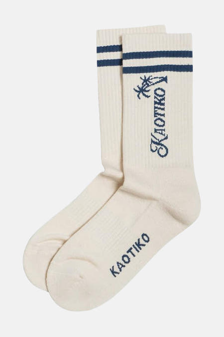 Chaussettes écru de KAOTIKO avec des rayures bleues et le logo de la marque avec un motif de palmier.