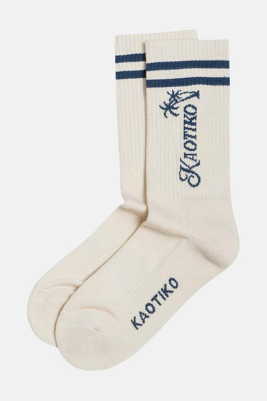 Chaussettes écru de KAOTIKO avec des rayures bleues et le logo de la marque avec un motif de palmier.