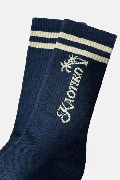 Chaussettes bleues de KAOTIKO avec des rayures blanches et le logo de la marque.