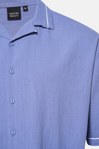 Chemise bleue à manches courtes de KAOTIKO, avec un col ouvert et une fermeture à boutons.