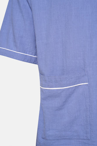 Chemise bleue à manches courtes de KAOTIKO, avec poche poitrine terminée par une patte blanche.