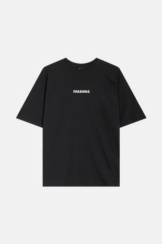 T-shirt noir à manches courtes de KAOTIKO, avec le texte "PARANOIA" sur la poitrine.