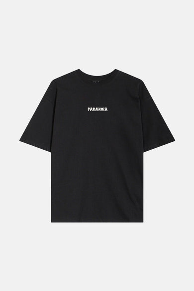 T-shirt noir à manches courtes de KAOTIKO, avec le texte "PARANOIA" sur la poitrine.