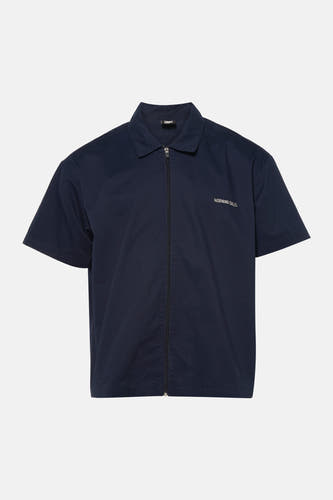 Chemise bleue à manches courtes de KAOTIKO, avec une fermeture éclair et le texte "MORNING CALLS" sur la poitrine.
