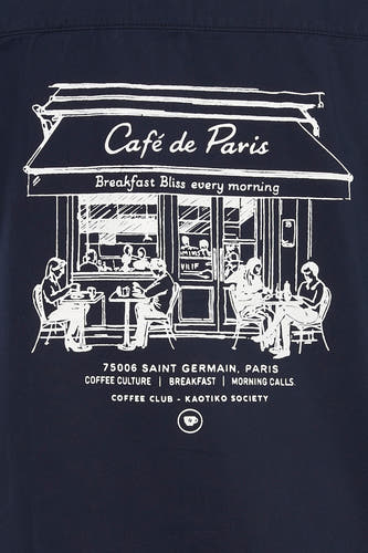 Chemise bleue à manches courtes de KAOTIKO, ornée d'un imprimé blanc d'un café parisien.