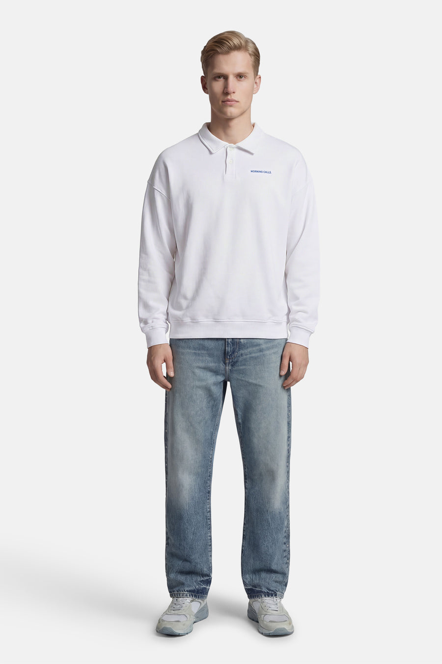 Pull blanc de KAOTIKO, à manches longues, porté avec un jean bleu et des baskets grises.