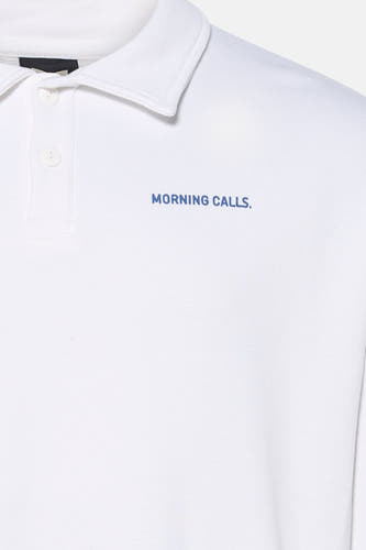 Pull blanc de KAOTIKO avec une courte patte de boutonnage et un petit imprimé texte bleu sur la poitrine.