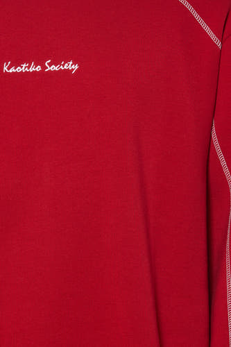 Pull rouge à col rond de KAOTIKO, avec coutures blanches sur l'épaule et imprimé texte.