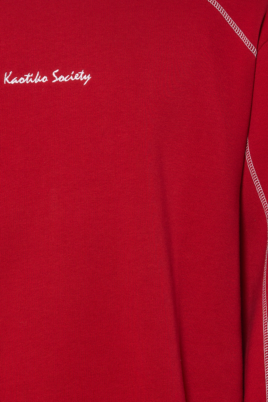 Pull rouge à col rond de KAOTIKO, avec coutures blanches sur l'épaule et imprimé texte.