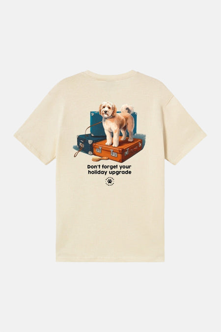 T-shirt écru de KAOTIKO avec un imprimé de chien sur des valises et le texte "Don't forget your holiday upgrade".
