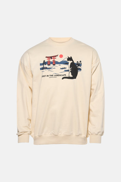 Pull écru de KAOTIKO avec un imprimé graphique d'un chat et d'un paysage japonais.