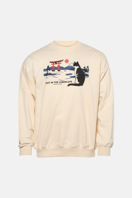 Pull écru de KAOTIKO avec un imprimé graphique d'un chat et d'un paysage japonais.