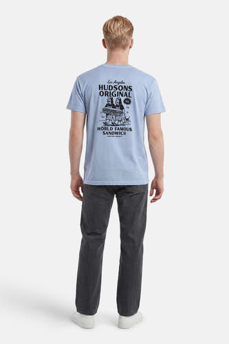 T-shirt bleu clair de KAOTIKO avec un grand imprimé graphique noir au dos de deux personnages portant un sandwich, porté par un homme avec un pantalon gris foncé et des baskets blanches.