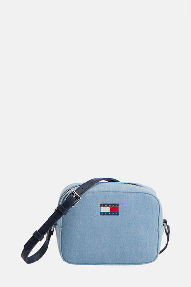 Sac à dos en denim bleu clair de TOMMY JEANS avec une ceinture bleu marine, porté avec un haut blanc et des jeans.