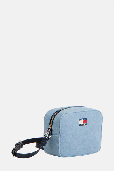 Sac à dos en denim bleu clair de TOMMY JEANS, avec fermeture éclair argentée et bandes noires.