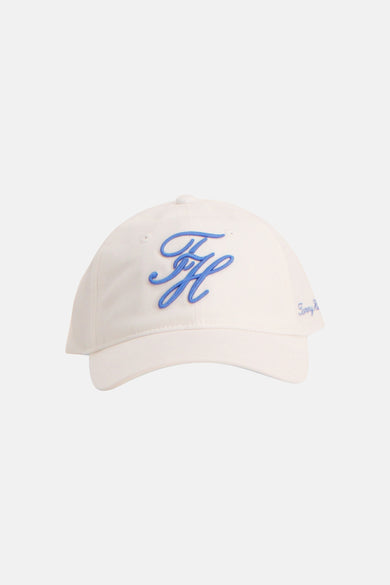Witte pet van TOMMY JEANS met een gestileerd blauw TH-logo en kleine blauwe letters op de zijkant.