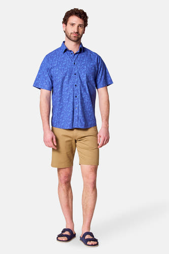 Shorts bruns de Bruce & Butler, portés avec un chemisier à fleurs bleues et des sandales bleues.