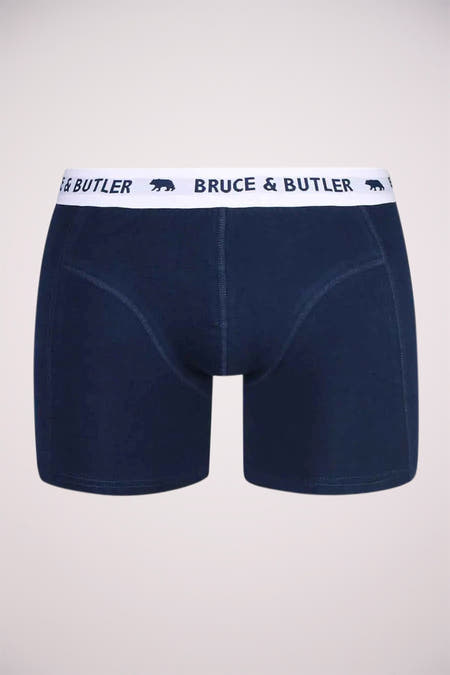 Boxer short bleu de Bruce & Butler, doté d'une ceinture blanche avec le nom de la marque et les logos.
