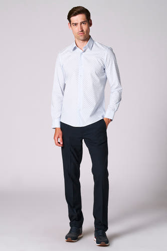 Chemise bleue à manches longues de Bruce & Butler, avec un fin motif à carreaux, associée à un pantalon foncé et des baskets.