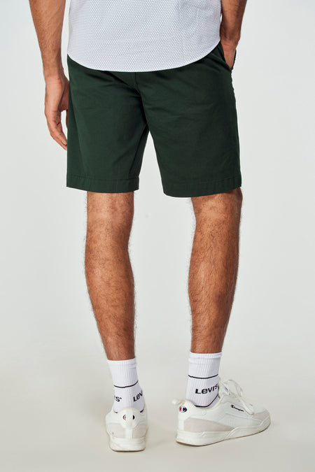 Short bermuda vert de Bruce & Butler, porté avec un t-shirt blanc et des baskets, vue de côté
