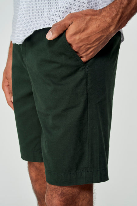Short bermuda vert de Bruce & Butler, mélange de coton, poche latérale, modèle avec main dans la poche, gros plan avant