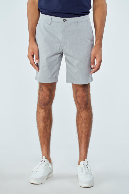 Short bleu de Bruce & Butler, porté avec des baskets blanches et un t-shirt bleu marine.