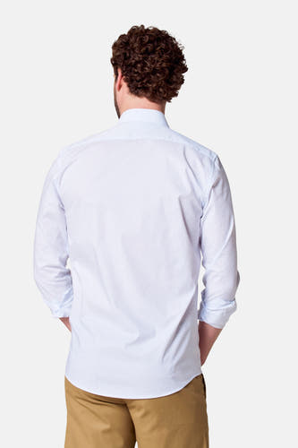 Chemise blanche à manches longues de Bruce & Butler, vue arrière, avec un imprimé subtil et des manches retroussées, associée à un pantalon kaki.
