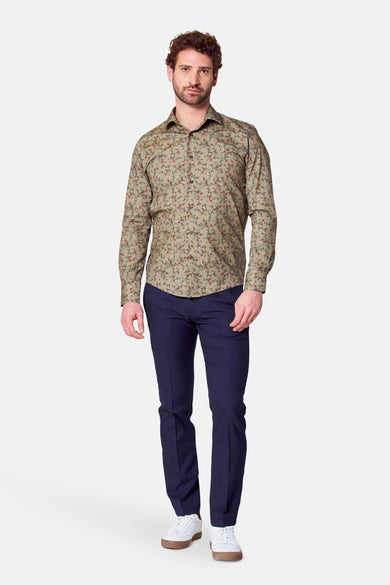 Chemise verte à manches longues de Bruce & Butler, avec un petit motif floral, associée à des pantalons bleu marine et des baskets blanches.