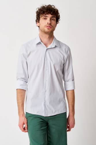 Chemise blanche à manches longues de Bruce & Butler, avec motif subtil, manches retroussées et portée avec un pantalon vert.
