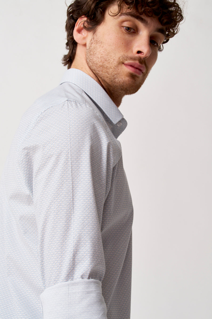 Chemise blanche à manches longues de Bruce & Butler, avec micro-motif bleu et orange subtil, vue de côté.