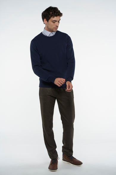 T-shirt bleu avec col rond de Bruce & Butler, porté sur une chemise à imprimé et un pantalon en corduroy marron.