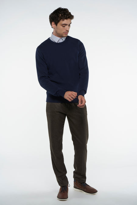 T-shirt bleu avec col rond de Bruce & Butler, porté sur une chemise à imprimé et un pantalon en corduroy marron.