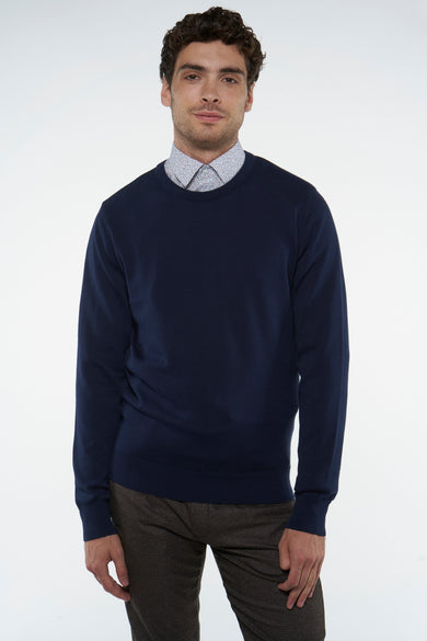 T-shirt bleu avec col rond de Bruce & Butler, porté sur une chemise à imprimé et un pantalon marron.