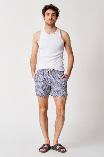 Maillot de bain bleu de Bruce & Butler, avec un motif floral et une chemise blanche.