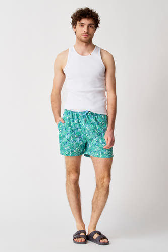 Légumes verts de Bruce & Butler, avec un motif de coquillages, portés avec une chemise blanche et des sandales.