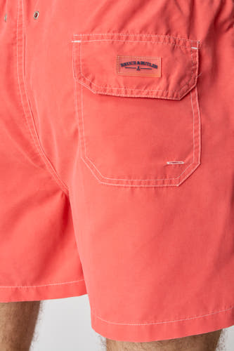 Orange broderie de Bruce & Butler avec une poche brodée et des points blancs, gros plan.