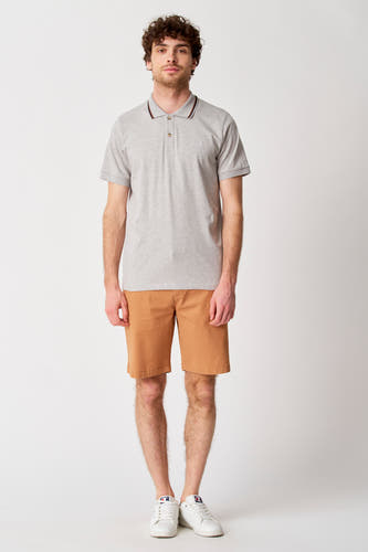 Short brun de Bruce & Butler, porté avec un polo gris et des baskets blanches.