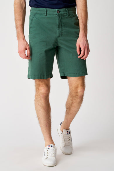 Short vert de Bruce & Butler, avec un nœud visible et porté avec des chaussures Champion blanches.
