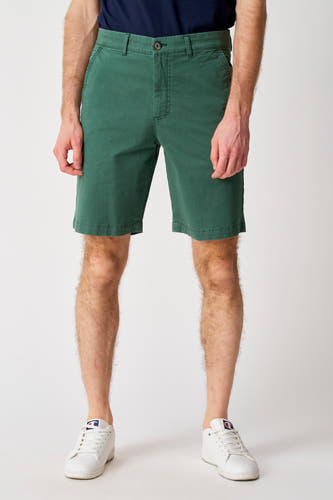 Short vert de Bruce & Butler, porté avec un t-shirt bleu foncé et des baskets blanches.
