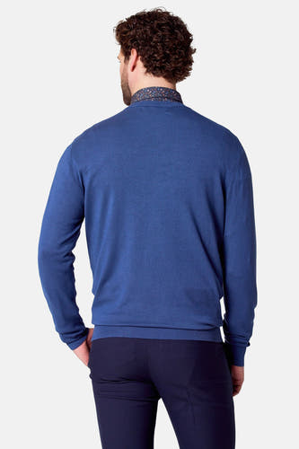 Pull à col V bleu de Bruce & Butler, avec collet de chemise visible.