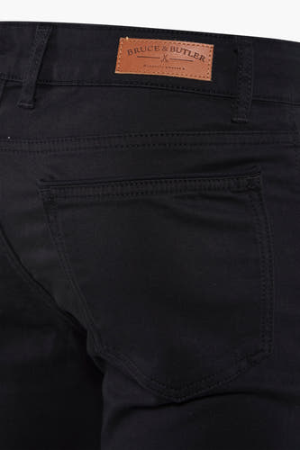 Pantalon noir de Bruce & Butler, avec poche arrière et étiquette en cuir sur la ceinture.