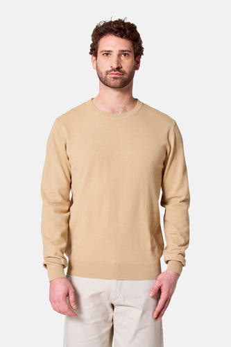 Gilet beige à col rond de Bruce & Butler, porté avec un pantalon léger.