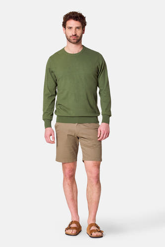 T-shirt vert avec col rond de Bruce & Butler, porté avec des shorts kaki et des sandales.