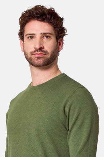 Groene trui met ronde hals van Bruce & Butler, close-up van een man met een baard.