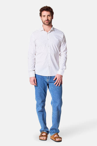Chemise blanche à manches longues de Bruce & Butler, dotée d'un motif de points subtil, portée avec des jeans et des sandales.